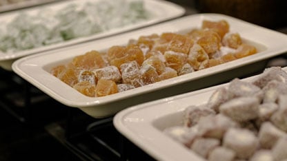 Close-up of trays filled with assorted powdered candies or jellies in different colors and flavors.