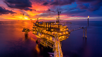  Oil platform at sea, lit up, at dusk