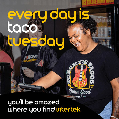 Two Torche's Taco employees smiling at the service counter